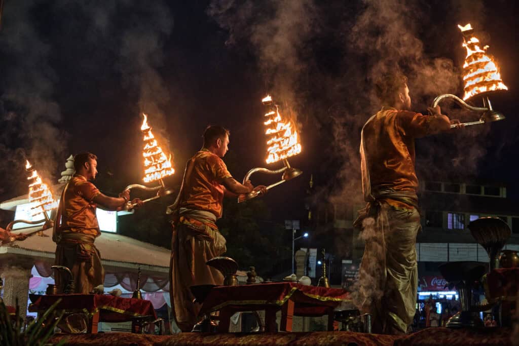 Morning Ganga Aarti at Assi Ghat during Subah-e-Banaras, with priests performing rituals by the river as the first light of day rises over the Ganges.